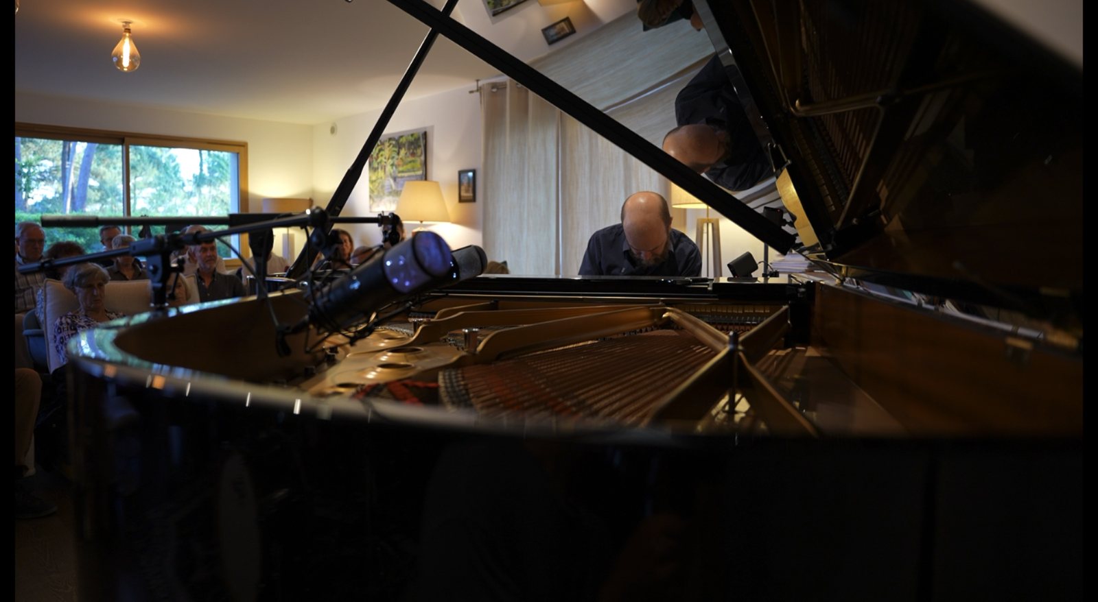 Augustin d'Assignies au piano, reflet dans le couvercle, à Vannes